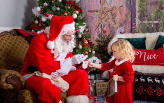 A-Girl-in-a-Red-Festive-Dress-Receives-a-Santa-Christmas-Ornament-from-Kris-Kringle-Himself