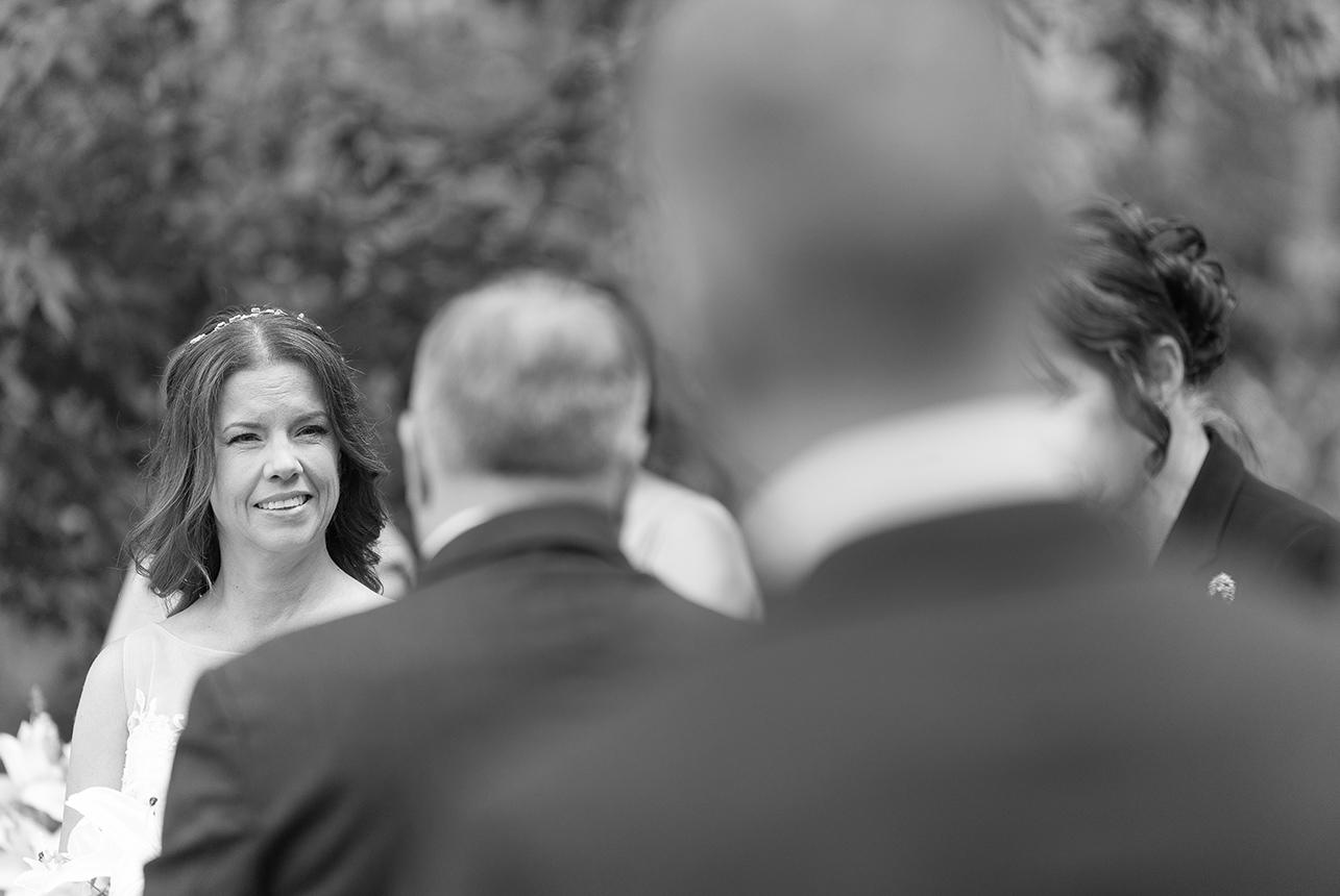 Bride smiling during ceremony vows, black and white photo