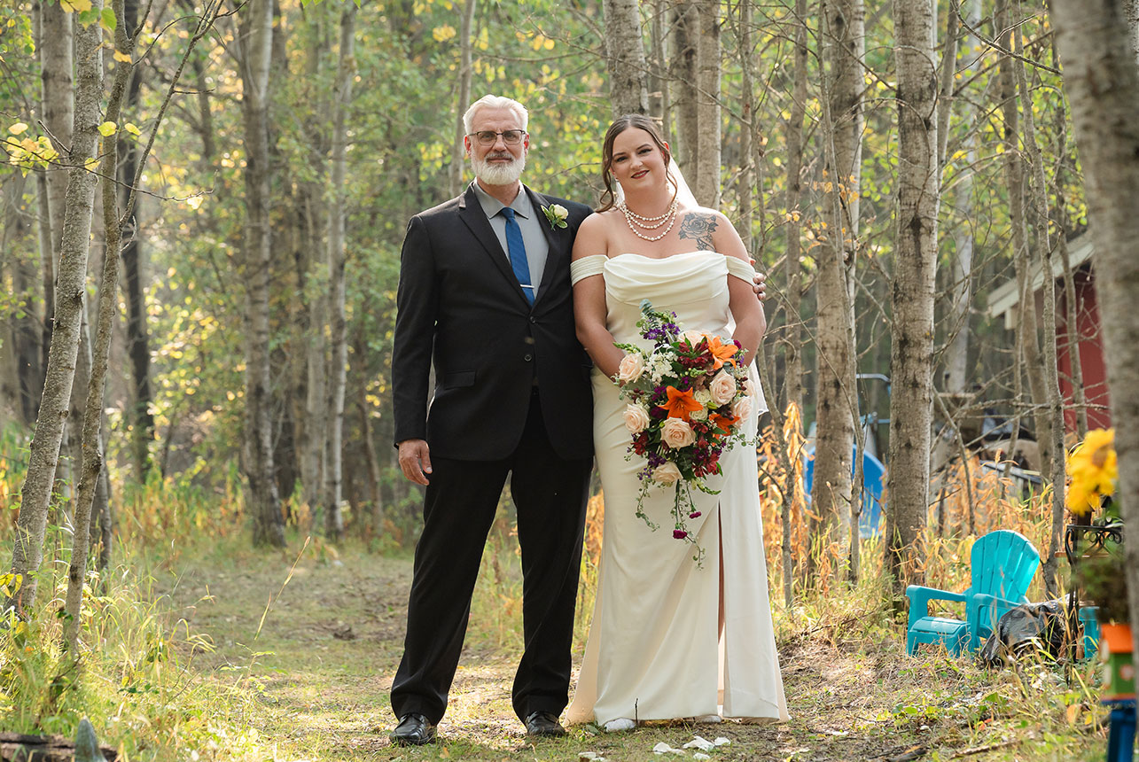 Bride and father step onto the enchanted forest path, beginning their walk toward the ceremony under a canopy of trees