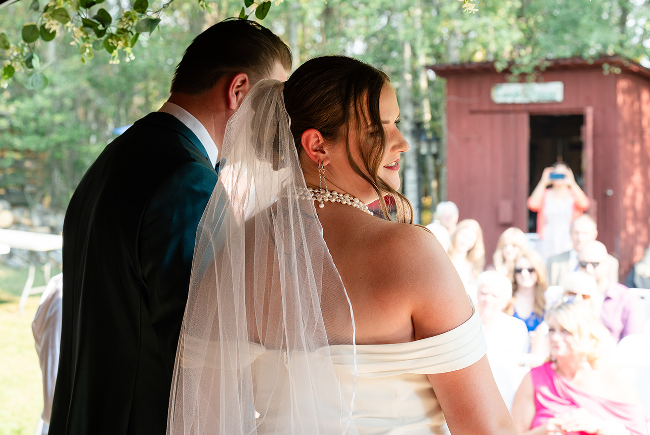 Bride and groom step off the ceremony stage as newlyweds, with guests and family blurred in the background