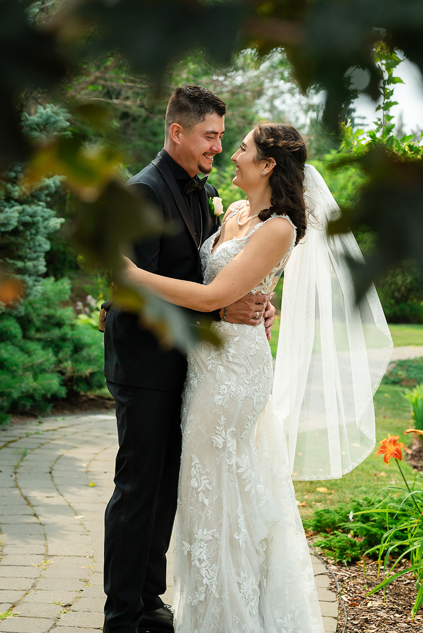 Portrait of the bride and groom framed by heart-shaped leaves and foliage, highlighting their upper bodies.