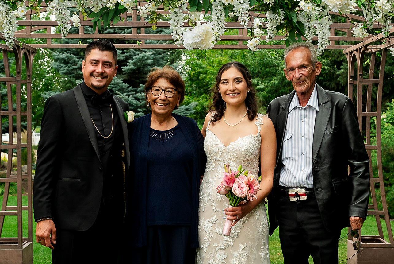 Bride and groom standing with their grandparents during an Edmonton wedding ceremony, sharing a joyful moment.