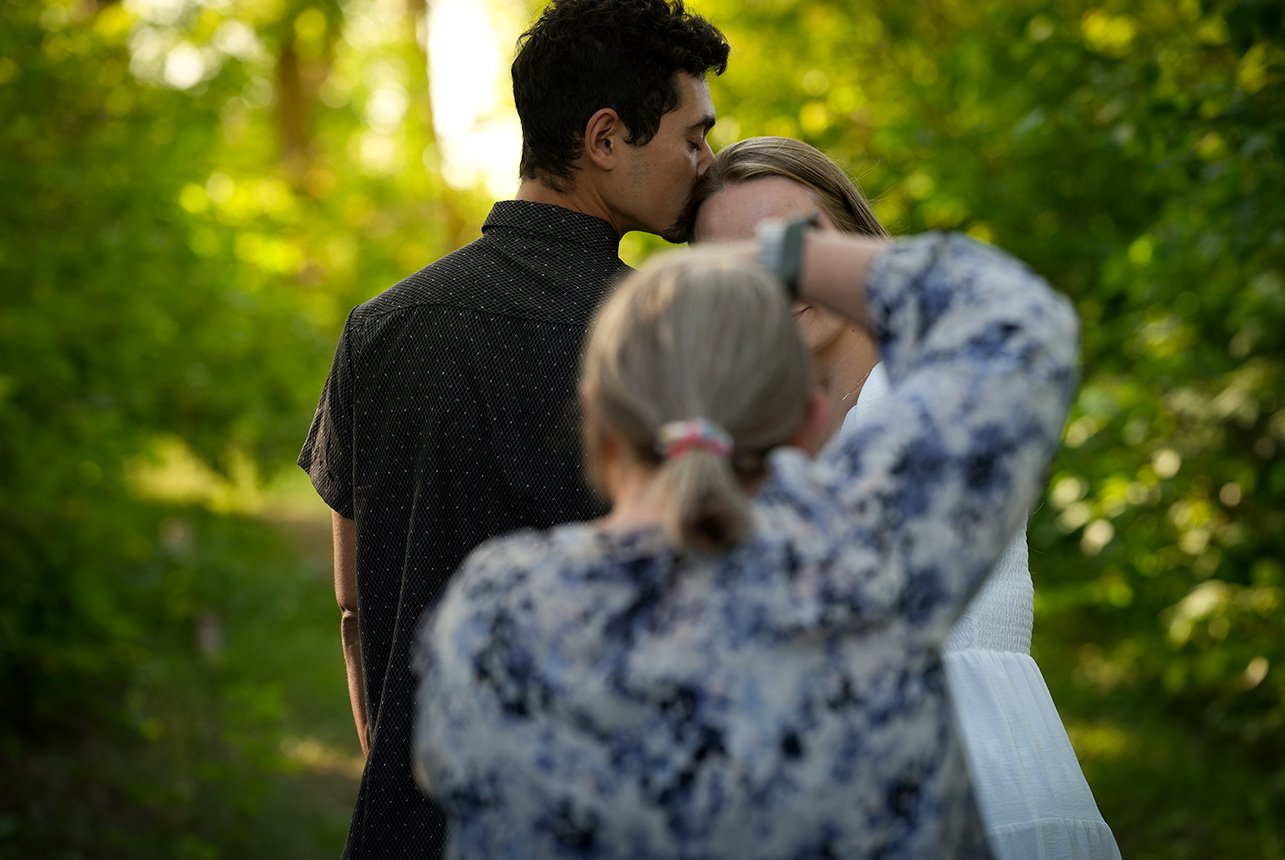 Catriona photographing an engaged couple during a golden hour session in Edmonton