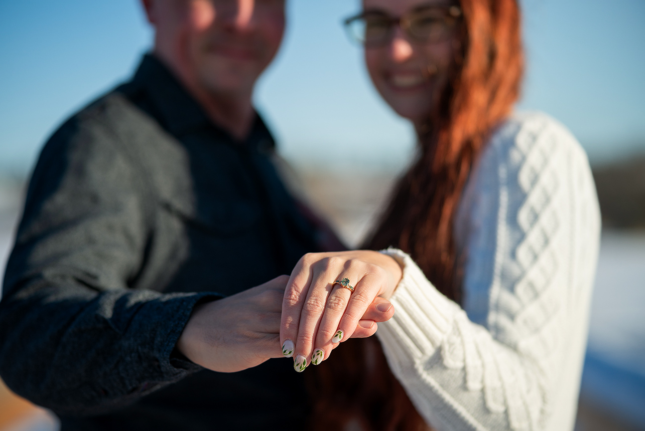 engaged couple ring closeup winter light