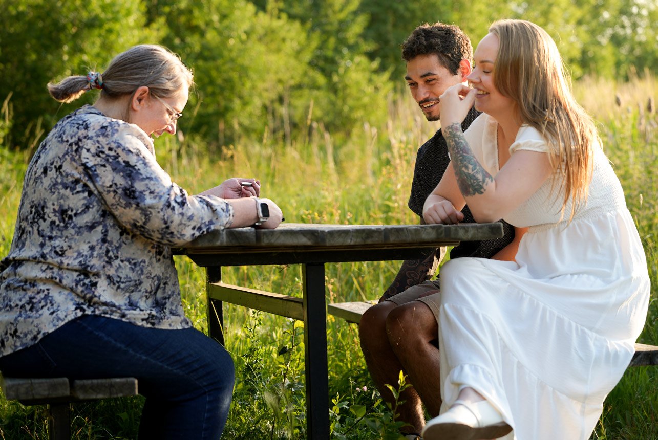 Photographer Catriona Hope sitting with engaged couple during planning session