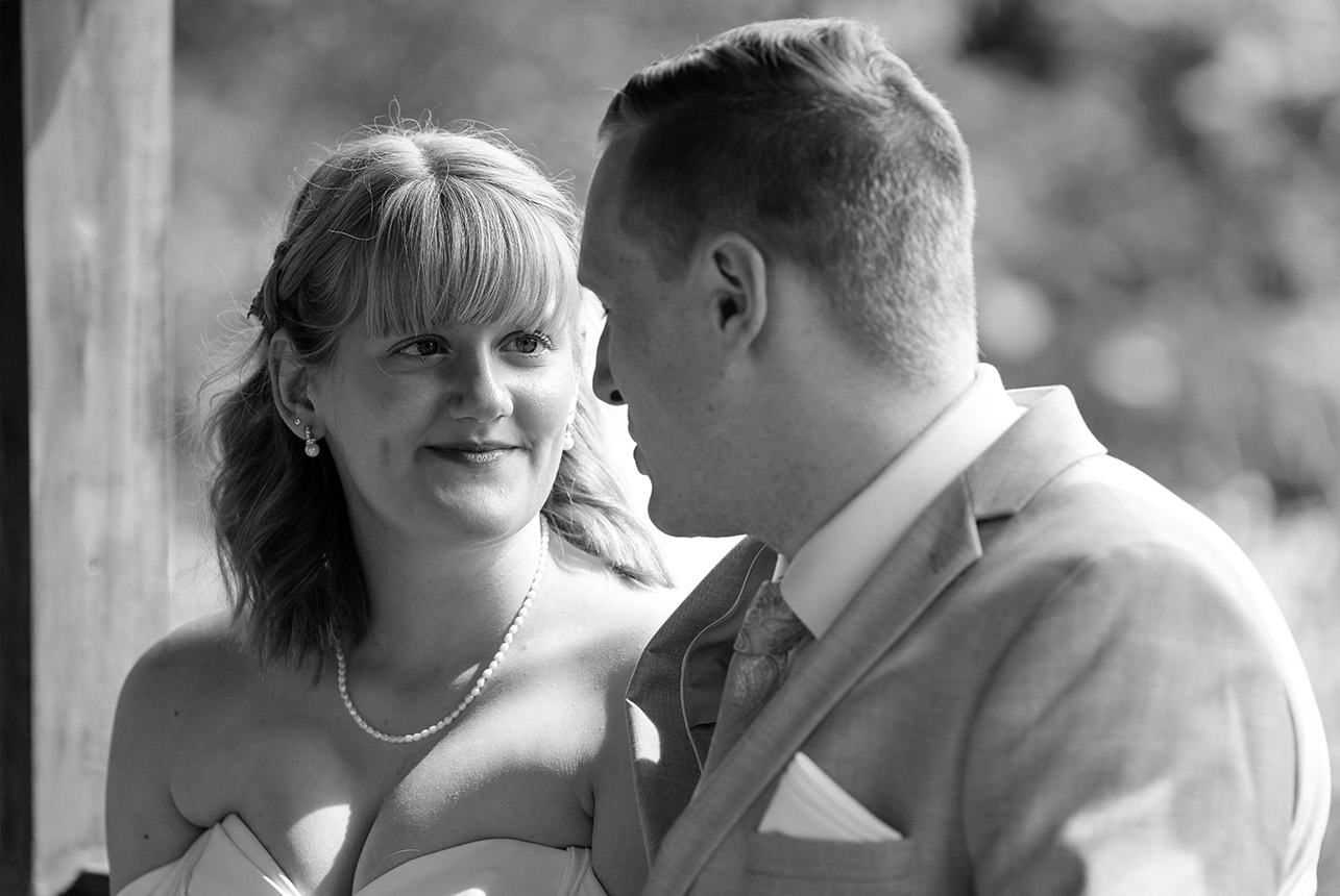 Bride and groom sharing an emotional moment in black and white under soft natural light