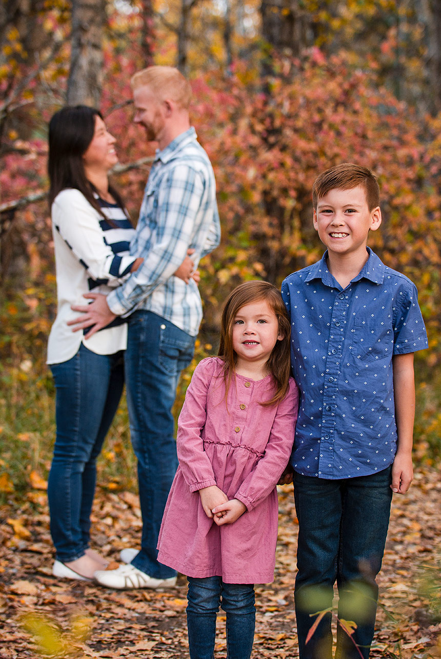 Children Posing in Fall, Parents in Background