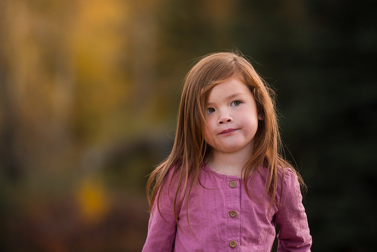 Young girl in a purple shirt during a fall photo session at Mactaggart Sanctuary