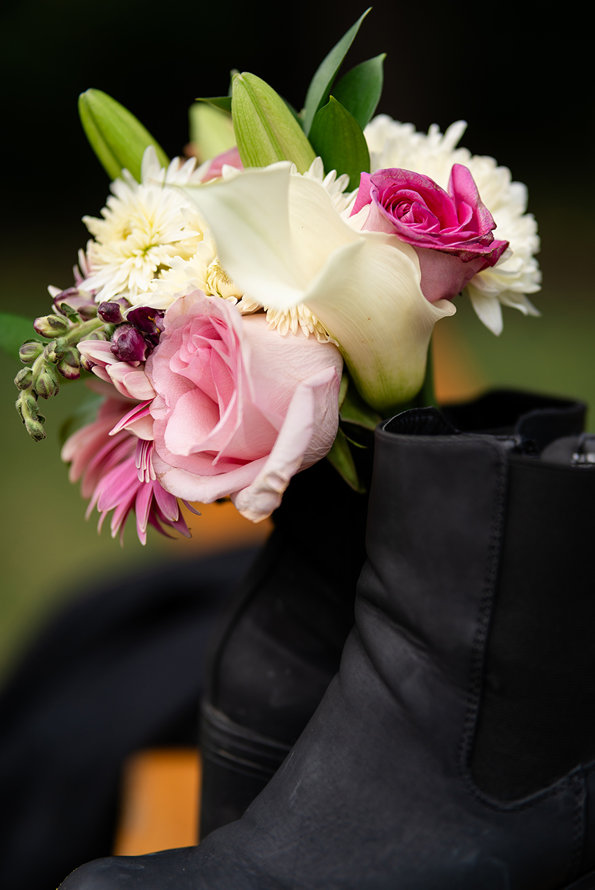 Close-up of elegant black leather high-heel boots adorned with floral accents, showcasing intricate details and stylish design.