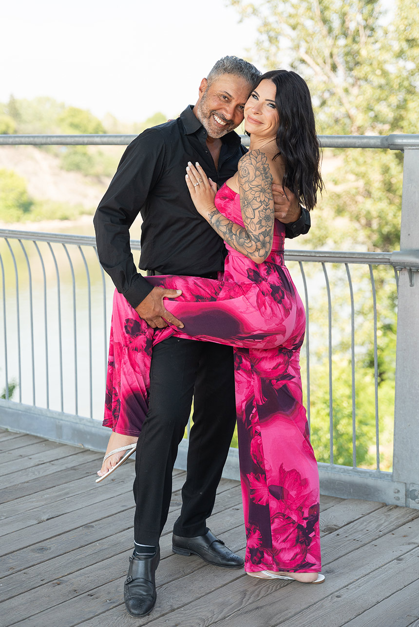 Playful couple pose on bridge above North Saskatchewan River