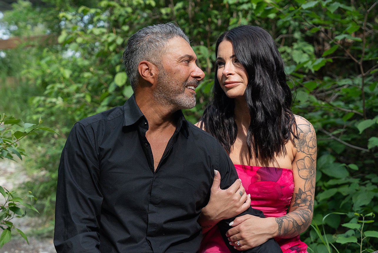 Engaged couple sitting together by forest trail near Tawatinâ Bridge