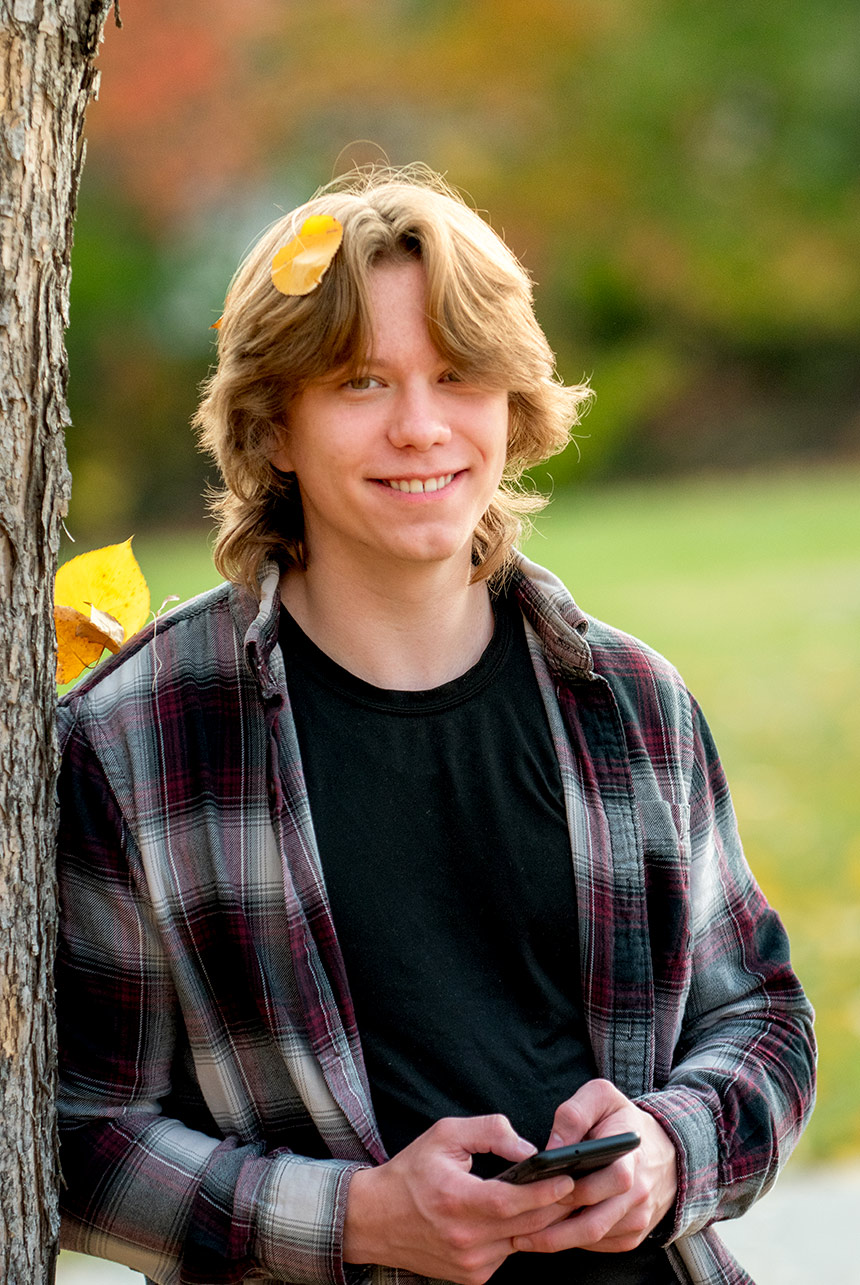 Teen boy smiling in a fall portrait at Ball Lake Island Park
