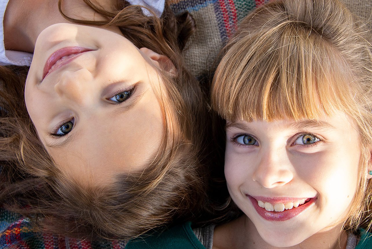 Two Sisters Gazing Up at the Sky with Joyful Smiles
