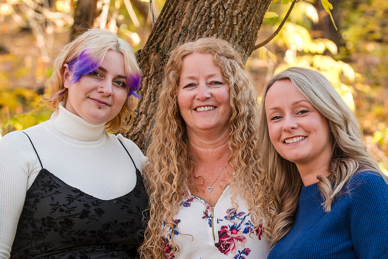 Three women posing together during an autumn portrait session in Fort Saskatchewan