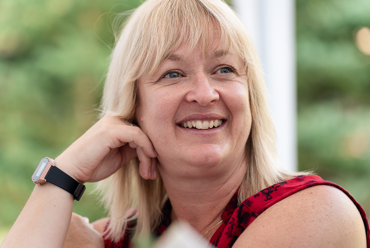 Candid close-up of a wedding guest watching a heartfelt speech during the reception, emotion in her expression