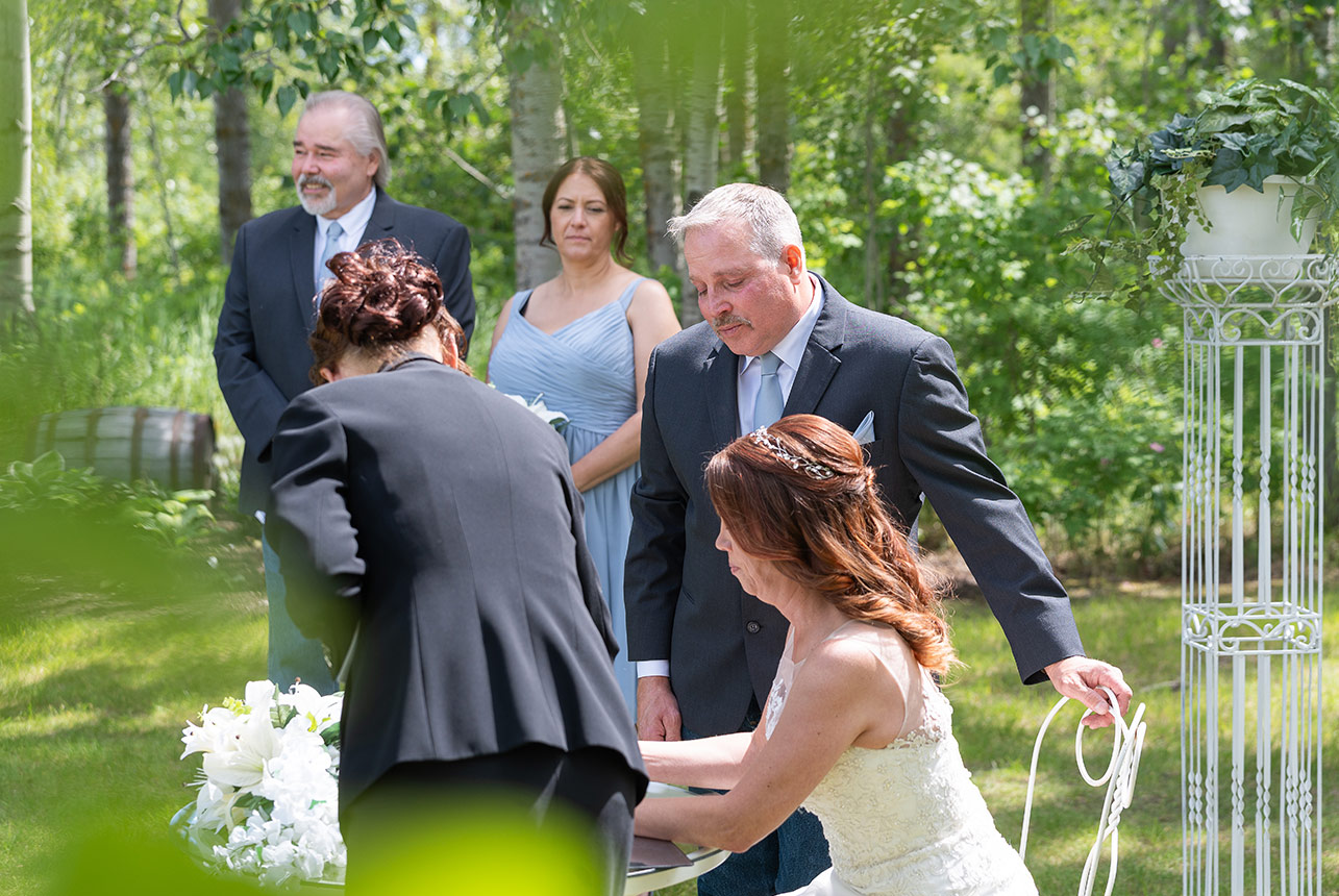 Bride and groom during wedding registry signing ceremony outdoors