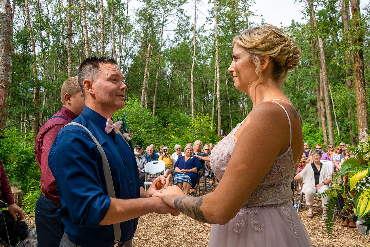 Bride and groom exchanging rings in outdoor wedding ceremony