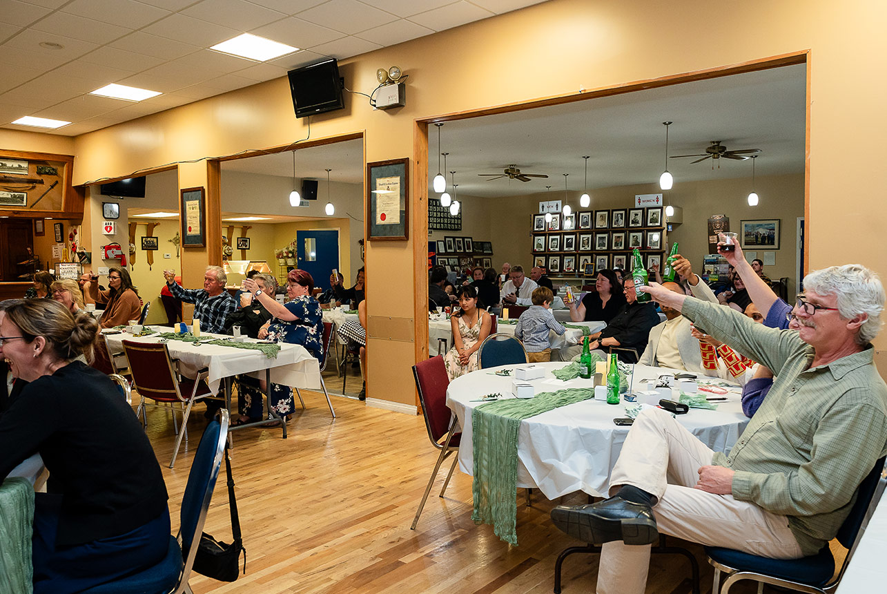 Wedding guests raise their glasses in a toast during the reception, celebrating the couple’s love