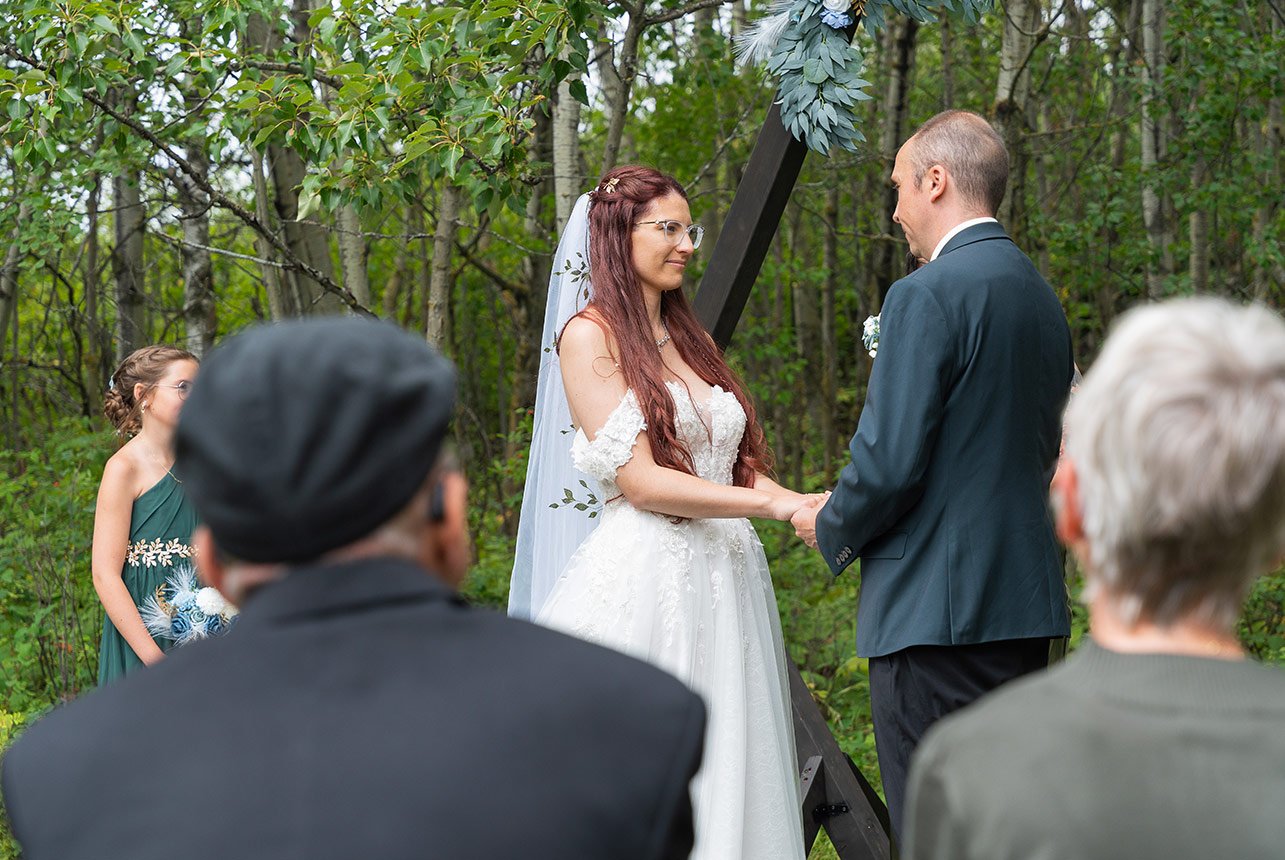Soft close-up as she listens to her partner’s vows, quiet emotion in her eyes
